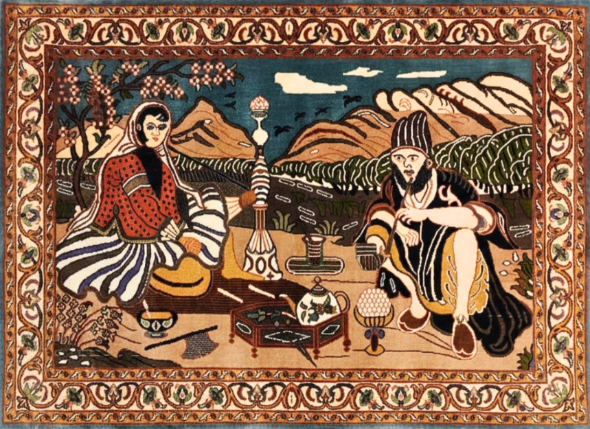 Handknotted pictorial handmade carpet by Yak Carpet featuring a traditional scene with figures, mountains and detailed floral border, used as wall art.